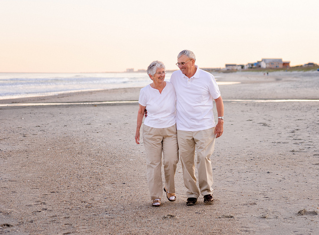 Grandparents walking down the beach together