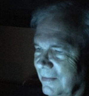 Author Wayne Caswell reading iPad at night.